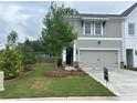 Inviting townhome features a two-car garage, well-maintained lawn, and stylish architectural details at 101 Priestwood Ln, Acworth, GA 30102