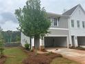 Side view of a new construction townhome with an attached two-car garage and landscaped yard at 101 Priestwood Ln, Acworth, GA 30102