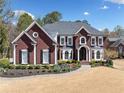 Two-story brick home with a beautifully landscaped front yard and curved walkway leading to the front door at 3795 Duckcove Way, Cumming, GA 30041