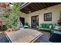 Private brick patio with lush greenery, comfortable seating, and a ceiling fan at 1791 Harper Nw St # H, Atlanta, GA 30318