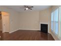 Bright living room with fireplace, ceiling fan, and many windows providing natural light at 4440 Cedar Bridge Walk, Suwanee, GA 30024