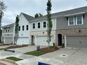 Street view of new construction townhomes showcasing landscaping, paved driveways, and modern design at 113 Priestwood Ln, Acworth, GA 30102