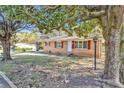 Charming brick ranch-style home with red shutters, mature trees, and landscaped front yard at 2739 Council St, Lithonia, GA 30058