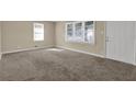 Bright living room with neutral paint and carpet, featuring two windows allowing for great natural light at 2739 Council St, Lithonia, GA 30058