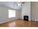 Inviting living room with hardwood floors, ceiling fan, fireplace and natural light from large windows at 5551 Panola Pl, Lithonia, GA 30058