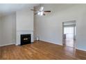 Bright living room with a fireplace, ceiling fan, hardwood floors and smooth transition into the kitchen at 5551 Panola Pl, Lithonia, GA 30058