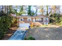 Split-level brick home featuring an attached two-car garage and a cozy front porch at 2727 Whites Mill Ct, Decatur, GA 30034