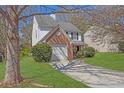 Well-maintained two-story home featuring a brick-accented garage and a green, landscaped lawn at 7176 Ravenwood Ln, Lithonia, GA 30038