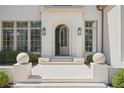 Elegant entrance with an arched doorway and white stone steps, with decorative greenery at 3364 Knollwood Nw Dr, Atlanta, GA 30305