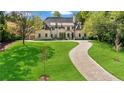 Beautiful home with a lush green lawn, long driveway, and meticulously maintained landscaping at 3364 Knollwood Nw Dr, Atlanta, GA 30305