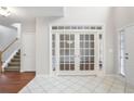 Grand foyer with tile flooring, double doors to office and staircase at 1603 Pinder Point Dr, Lawrenceville, GA 30043