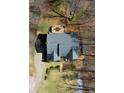 Aerial view of a home showcasing a deck with a table and chairs, set among mature trees at 7492 Shadburn Ferry Rd, Cumming, GA 30041