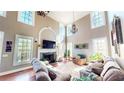 Bright, open living room with a fireplace, large windows, and hardwood floors at 7492 Shadburn Ferry Rd, Cumming, GA 30041