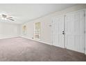 Bright living room with new carpet, ceiling fan, and double doors leading to backyard at 235 Shallowford Nw Rd, Kennesaw, GA 30144