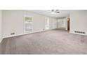 Spacious living room bathed in natural light, featuring neutral paint, new carpet, and view of backyard at 235 Shallowford Nw Rd, Kennesaw, GA 30144