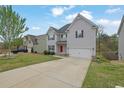 Beautifully landscaped front yard of a two-story home featuring a driveway and a red front door at 3945 Hamilton Cove Ct, Cumming, GA 30028