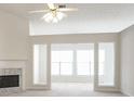 Bright living room featuring a fireplace, fan, and large windows, offering a welcoming atmosphere at 1056 Fern Valley Way, Dacula, GA 30019