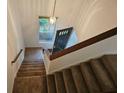A carpeted staircase with wooden handrail next to a window and a dark-colored door in a bright, naturally lit entryway at 2209 N Forest Trl, Dunwoody, GA 30338