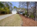 View of a well-maintained home featuring a quaint front porch and a spacious front yard landscape at 525 Hilliard Ct, Suwanee, GA 30024