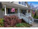 Inviting front porch area with charming decor, including flower baskets, seating, and a clear view of the home's entrance at 525 Hilliard Ct, Suwanee, GA 30024