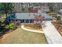 Ranch-style home featuring a lush lawn, walkway, and a driveway leading to a two-car garage at 1564 Pedro Sw Dr, Mableton, GA 30126