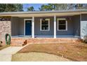 Close-up of the inviting covered front porch with brick accents and a vibrant blue front door at 1564 Pedro Sw Dr, Mableton, GA 30126