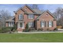 Charming brick two-story home featuring manicured lawn, mature shrubs, complemented by dark shutters and a classic front door at 3891 Greensward Nw Vw, Kennesaw, GA 30144
