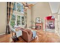 Bright living room with hardwood floors, fireplace, and a large window at 4370 Landover Way, Suwanee, GA 30024