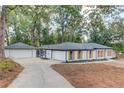 Side view of a well-maintained ranch home with a long driveway and detached garage at 105 Simonton (Tract 1) Se Rd, Lawrenceville, GA 30046