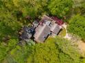 Aerial view of a secluded home with mature trees and roofing, offering privacy and natural beauty at 2977 Glover Dr, Cumming, GA 30040