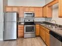 Kitchen features stainless steel appliances, wood cabinets, and gray countertops at 1455 Riverrock Ct, Riverdale, GA 30296