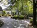 Elegant home with a gated entrance, lush greenery, and a beautifully paved driveway at 3900 Randall Ridge Nw Rd, Atlanta, GA 30327