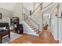 Welcoming foyer with staircase, hardwood floors, and view into other living spaces at 5388 Frazer Rd, Buford, GA 30518