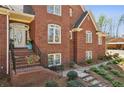Charming brick home's front entrance with steps, ornate door, and blossoming landscaping at 5388 Frazer Rd, Buford, GA 30518