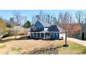 Charming two-story home with a rocking chair front porch, manicured lawn, and mature trees at 114 Hardwood Ln, Canton, GA 30115