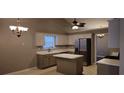 Well-lit kitchen featuring an island, stainless steel appliances, neutral cabinets and countertops at 5763 Dexters Mill Pl, Buford, GA 30518