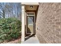 A covered front entrance featuring brick facade and trimmed shrubbery, and clearly visible house number at 2271 Oakland Downs Way, Lawrenceville, GA 30044