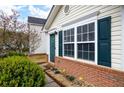 Close-up view of a home's entrance, highlighting its well-kept garden and brick accents beneath the window at 115 Oak Grove Pl, Acworth, GA 30102