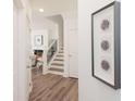 Inviting hallway with wood floors, a staircase, decorative art, and a glimpse of the living room at 2698 Ne Almand Ne Ln, Conyers, GA 30013