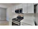 This kitchen features white cabinets, stainless steel appliances, and quartz countertops at 3035 Sherbourne Dr, Lithonia, GA 30058