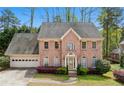 Elegant two-story brick home featuring a two-car garage, lush landscaping, and a classic architectural design at 6317 Southland Forest Dr, Stone Mountain, GA 30087
