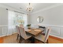 Elegant dining room with wainscoting, chandelier lighting, and a large window at 813 Topaz Vly, Canton, GA 30114