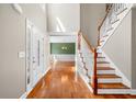 Bright foyer with hardwood floors, a staircase, and views into the formal dining room at 100 Oakwind Pkwy, Canton, GA 30114