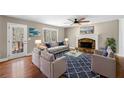 Cozy living room featuring a stone fireplace, plush seating, and a ceiling fan at 100 Oakwind Pkwy, Canton, GA 30114