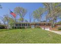 Charming brick home with an American flag, lush green lawn, mature trees and a welcoming front entrance at 3969 Potomac Nw Dr, Kennesaw, GA 30144