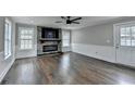 Cozy living room with stone fireplace, ceiling fan, and hardwood floors at 5155 Rosestone Nw Dr, Lilburn, GA 30047