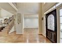 Spacious foyer with hardwood flooring, staircase, and decorative front door at 5190 Deerlake Dr, Alpharetta, GA 30005