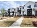 Modern townhomes with white and dark exteriors, brick accents, and freshly laid sod at 634 Skytop Dr # 155, Cumming, GA 30040