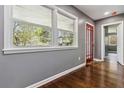 Bright living room with hardwood floors, gray walls, a large window, and a red-trimmed doorway at 2267 Bryant Dr, East Point, GA 30344