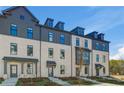 Wide angle view of townhomes featuring neutral brick and dark trim, as well as meticulous landscaping that creates a welcoming atmosphere at 608 Marimba Pike, Mcdonough, GA 30253